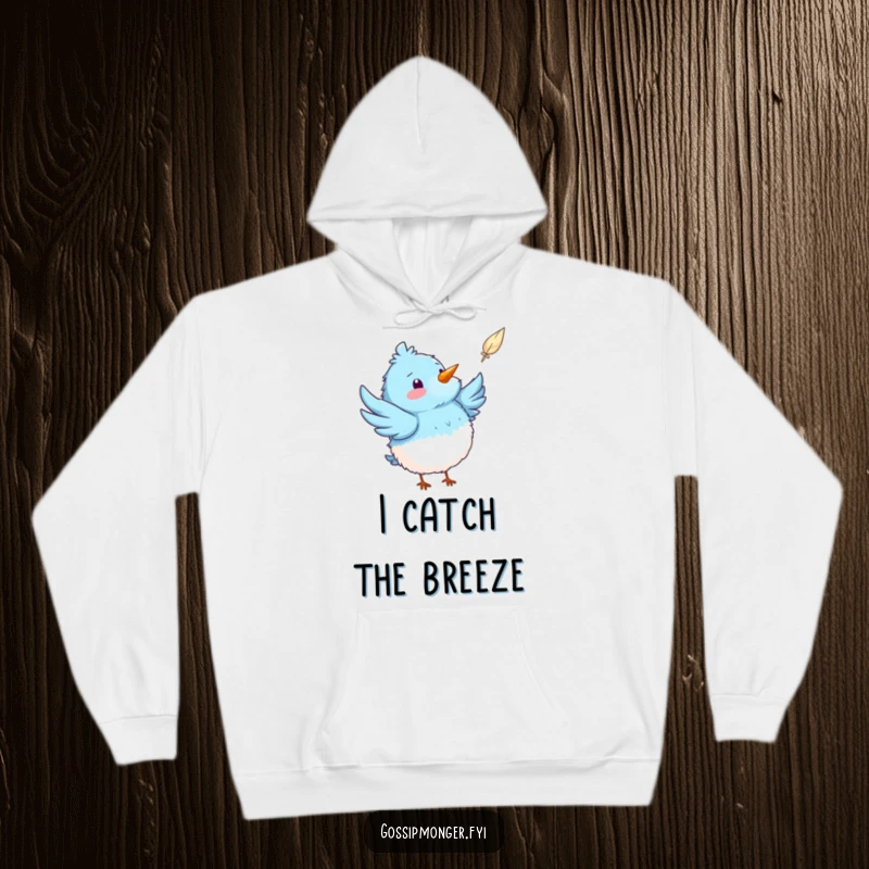 Funny fluffy blue bird hoodie showing a bird pointing with excitement at a floating feather, offering warmth and whimsical charm.