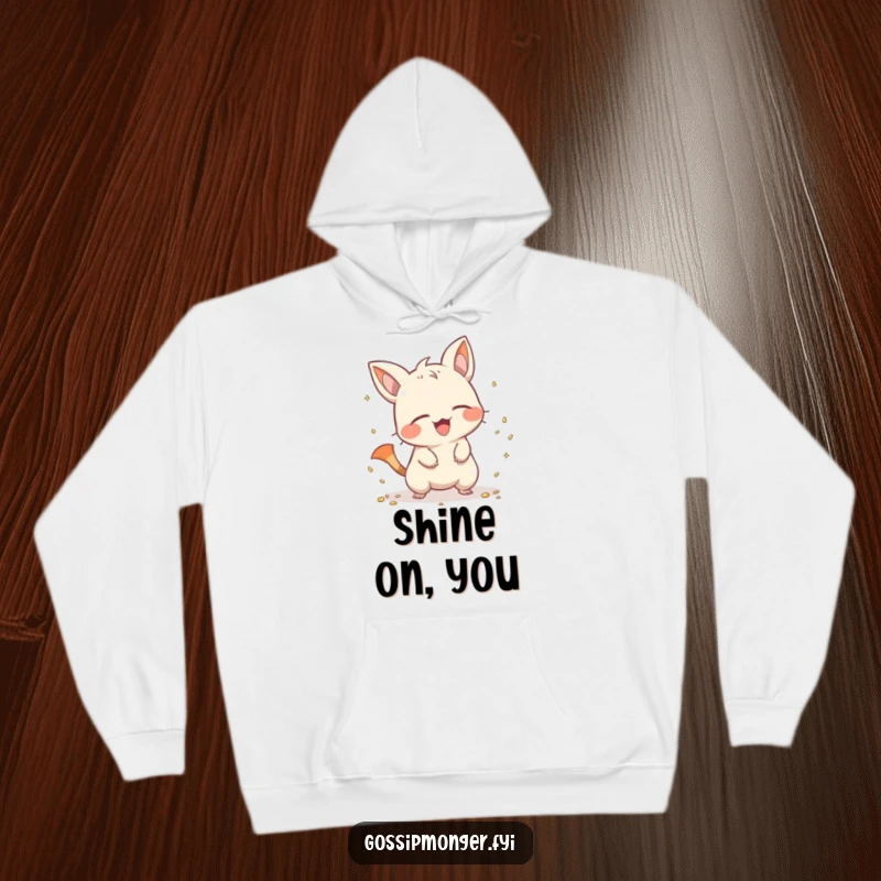 Funny creature with a pointy tail scattering shiny objects with a giggle, featured on a soft hoodie, radiating playful mischief and warmth.